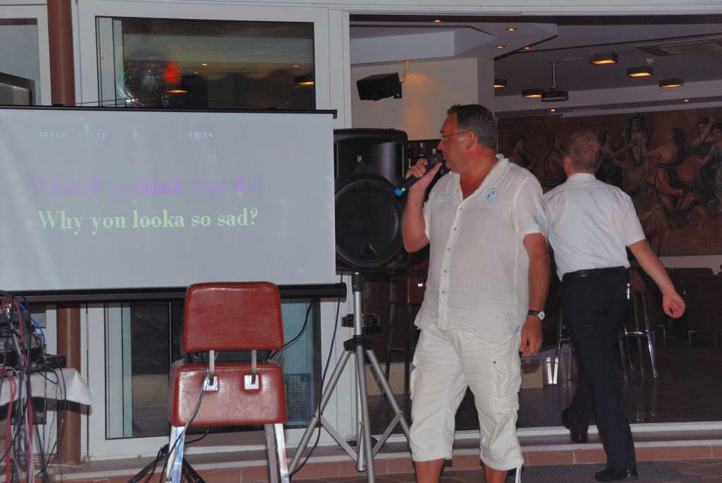 A guest singing karaoke with a lyrics screen